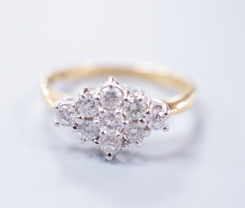 A modern 18ct gold and nine stone diamond set shaped cluster ring, size P, gross weight 4.3 grams